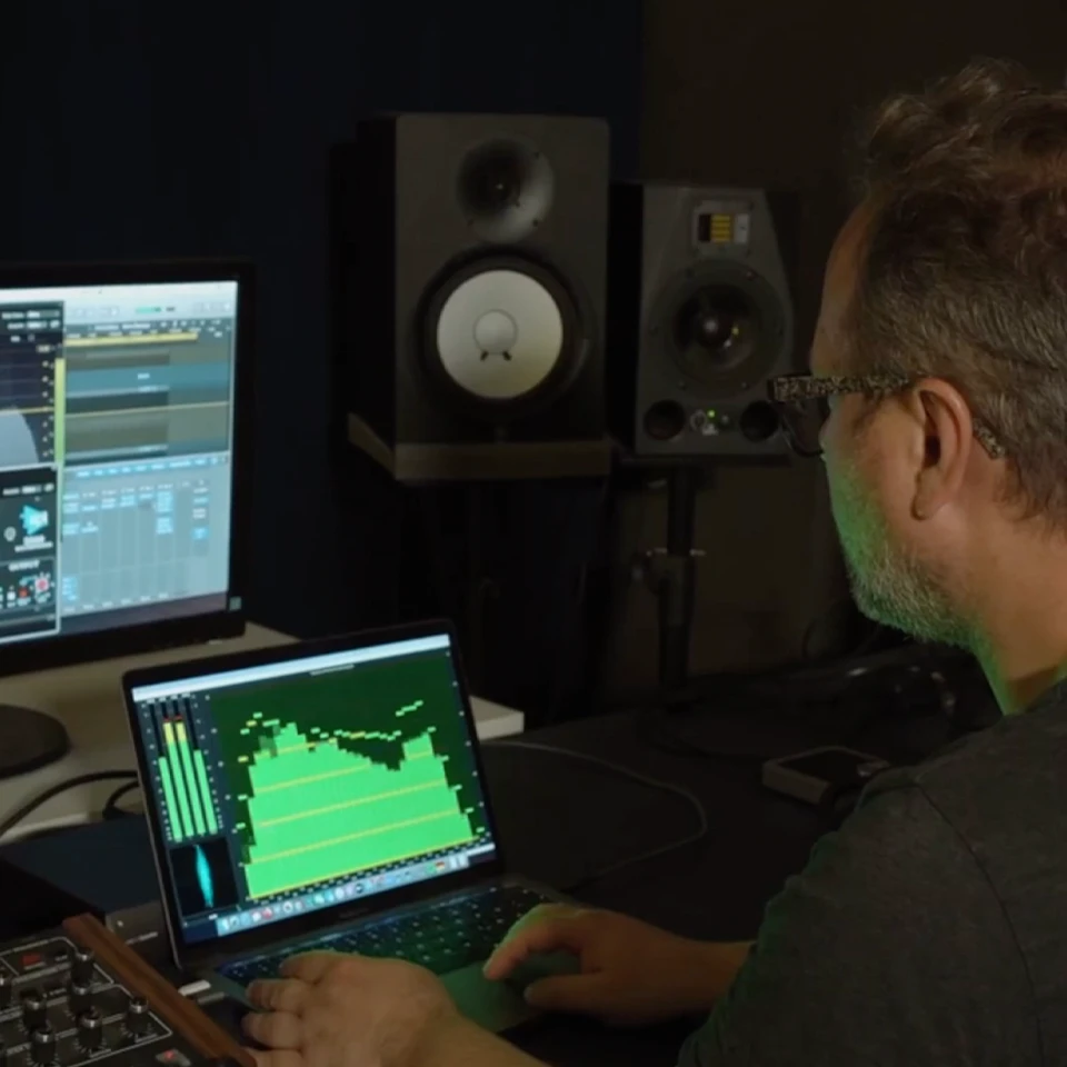 artist Insect O. looking at computer screens with music software